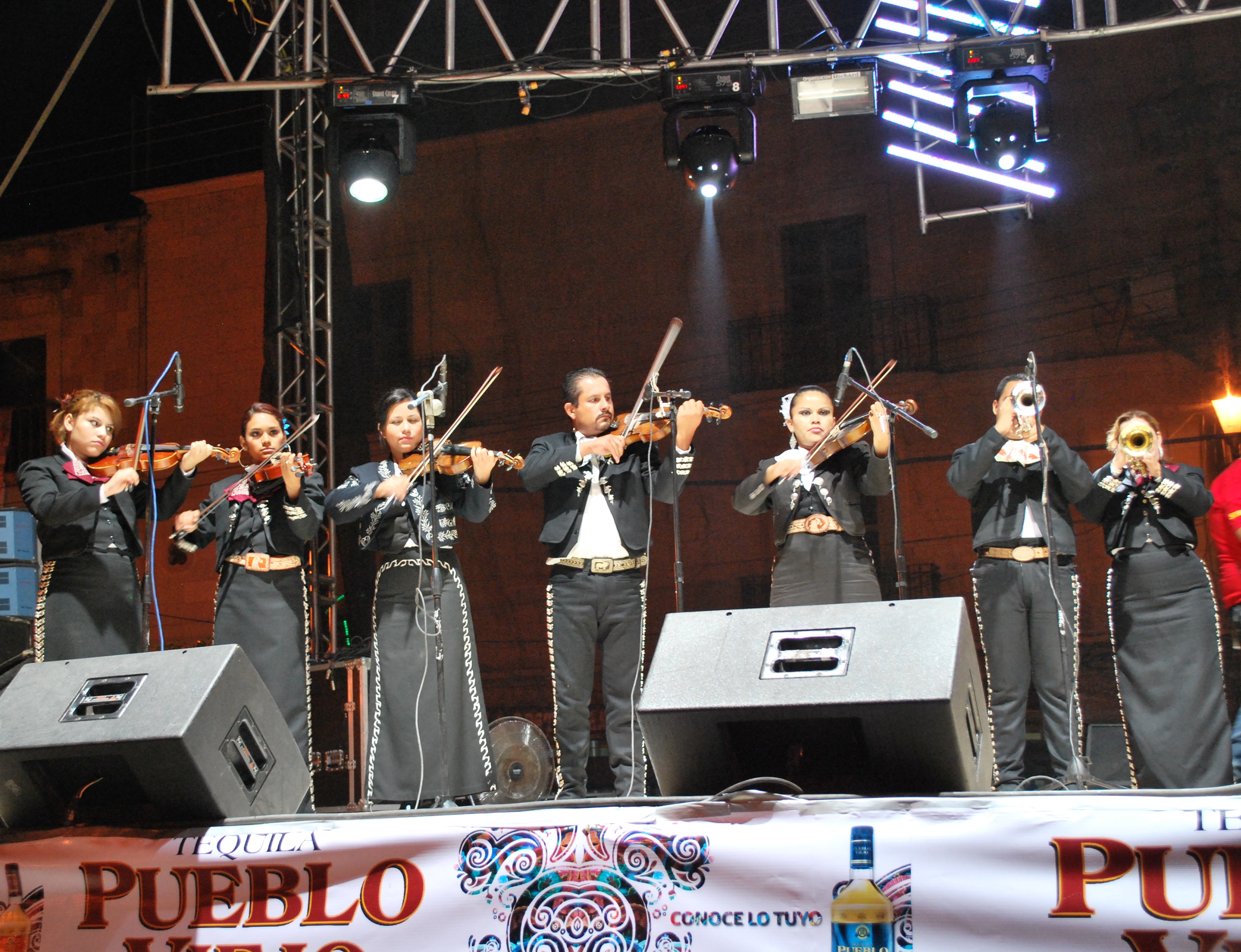 A Mariachi band performing. Mariachi music, with its distinctive instrumentation and attire, is a globally recognized symbol of Mexican musical tradition and cultural identity.