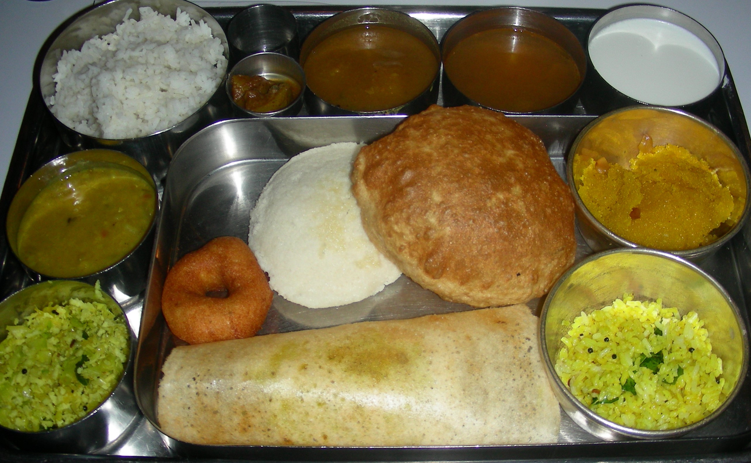 A South Indian vegetarian thali, or platter, showcasing a variety of dishes like rice, sambar, rasam, curries, and accompaniments, reflecting the regional diversity and emphasis on vegetarianism in parts of India.