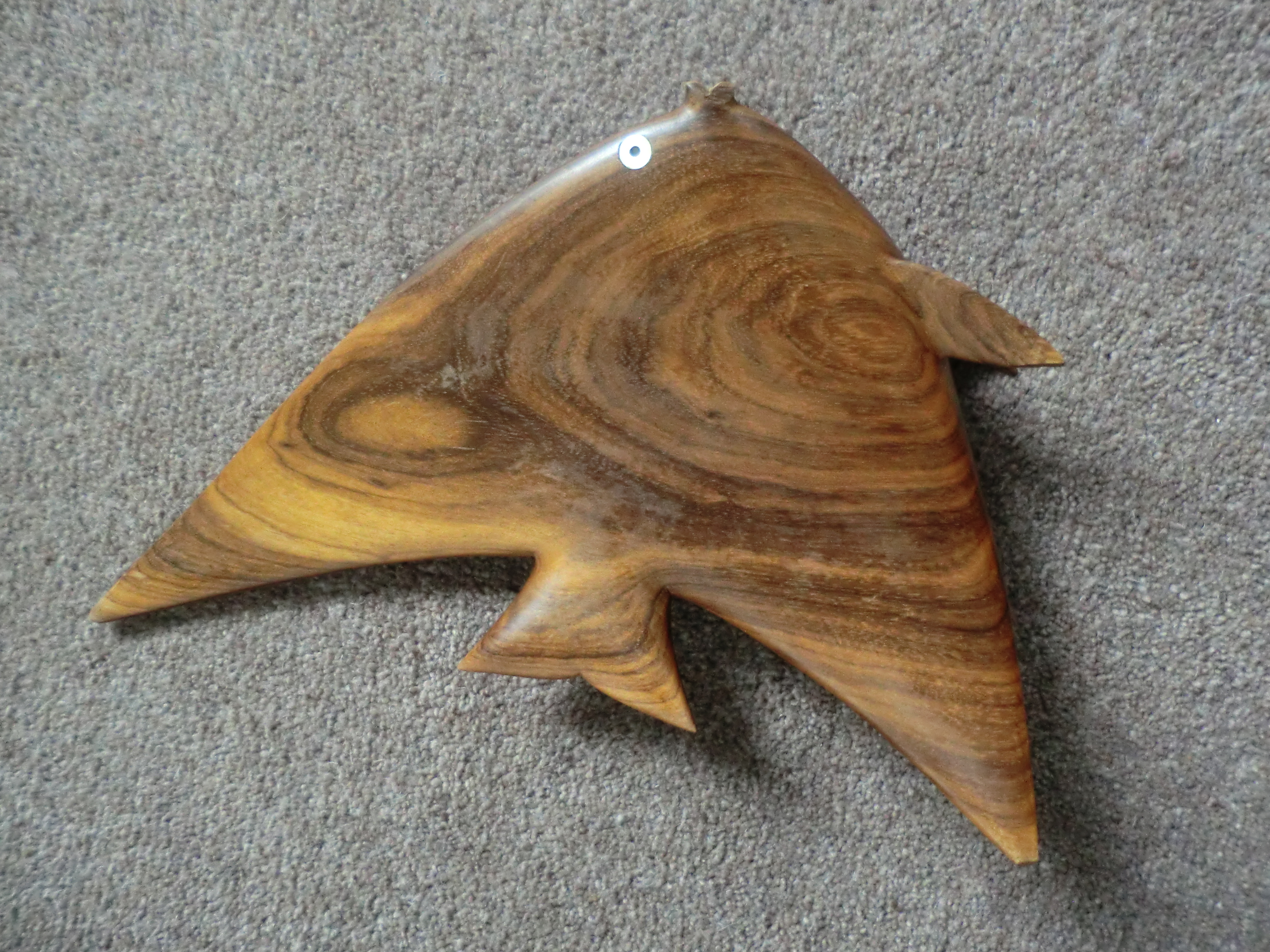 Ukiran ikan kayu dengan detail halus.