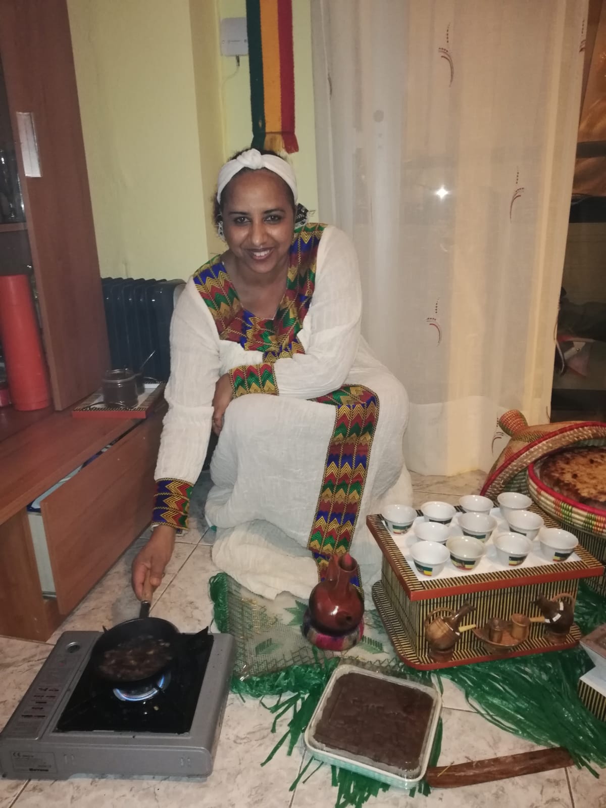 An Ethiopian woman roasting green coffee beans as part of the traditional coffee ceremony.