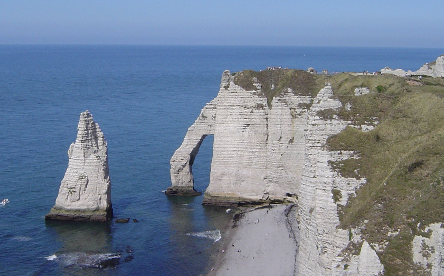 Tebing di Étretat, Normandia, menunjukkan ciri khas pantai dengan iklim laut.