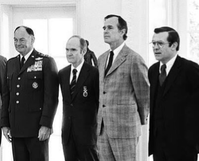 Setiausaha Pertahanan Donald Rumsfeld bersama Pengerusi Ketua-ketua Staf Bersama Jeneral George S. Brown, Penasihat Keselamatan Negara Leftenan Jeneral Brent Scowcroft, dan Pengarah C.I.A. George H. W. Bush di Pejabat Oval, Rumah Putih, 11 Mac 1976.