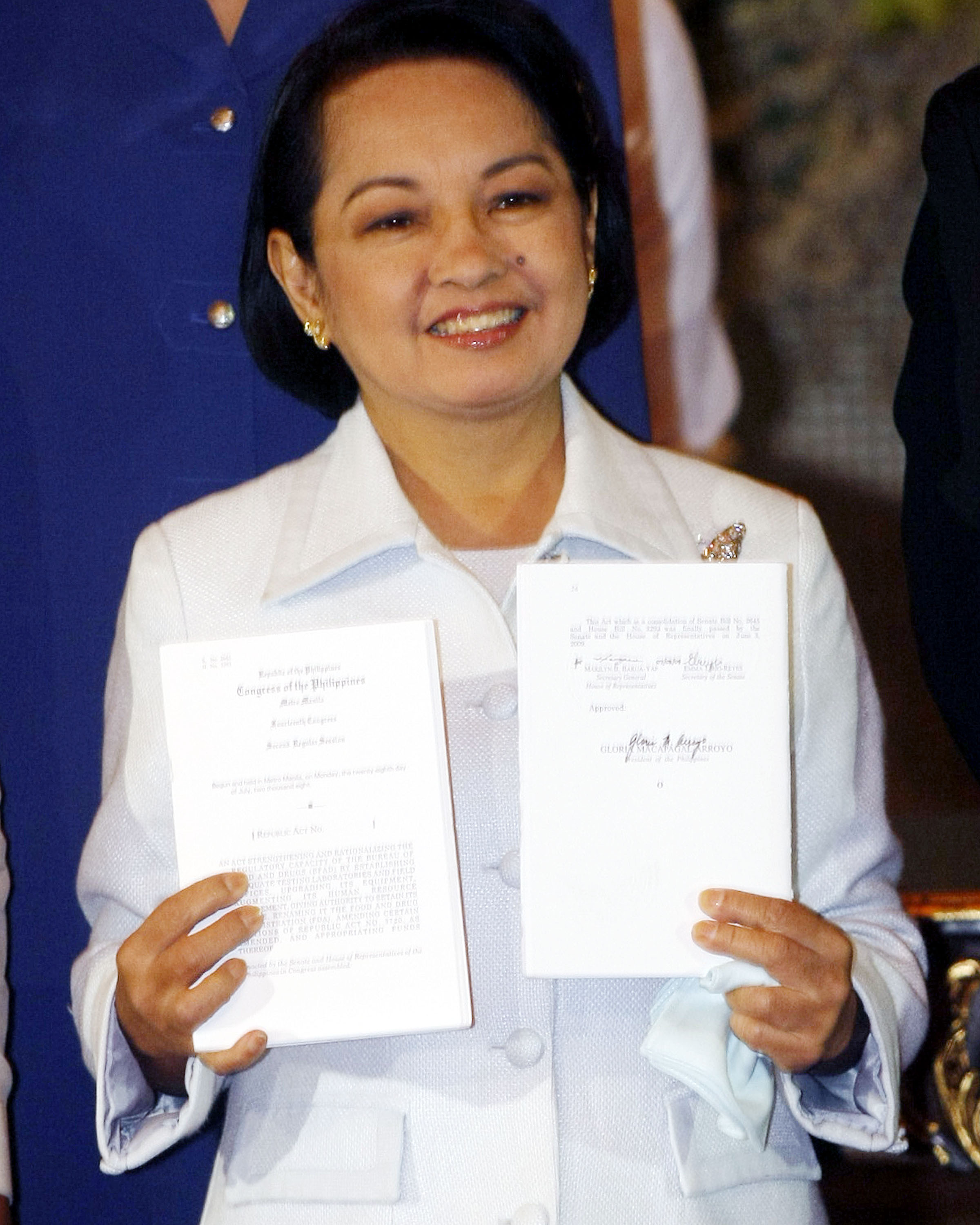 Arroyo showing a copy of Republic Act No. 9711 after a signing ceremony, August 18, 2009.