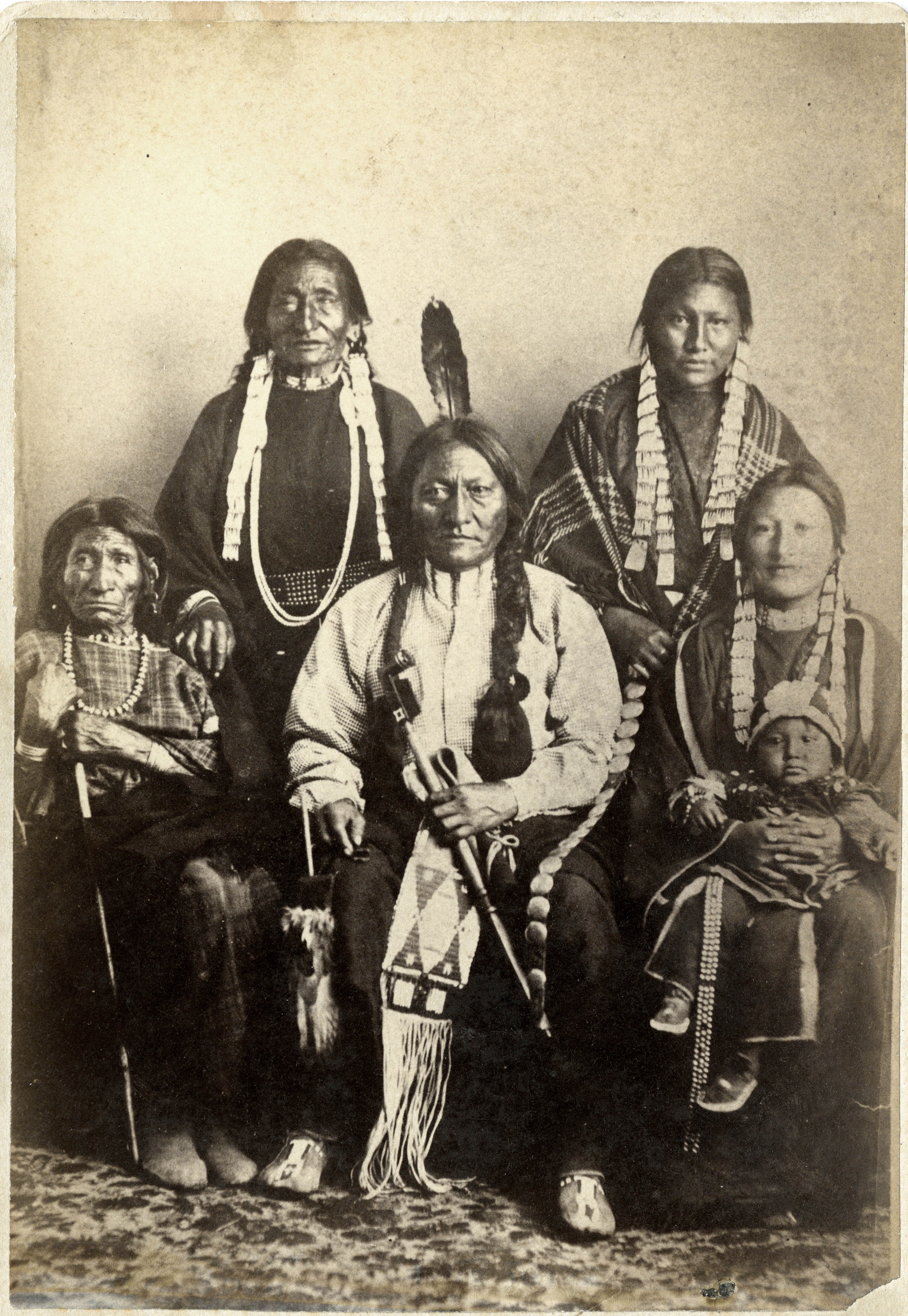 Sitting Bull and family in 1881 at Fort Randall. Rear L-R: Good Feather Woman (sister), Walks Looking (daughter); Front L-R: Her Holy Door (mother), Sitting Bull, Many Horses (daughter) with her son, Courting a Woman.